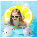 Criança na piscina sorrindo ao brincar com o brinquedo baleia.