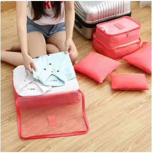 Pessoa organizando roupas no Kit Organizador de Malas para Viagem para facilitar o acesso durante a viagem. Cor rosa.